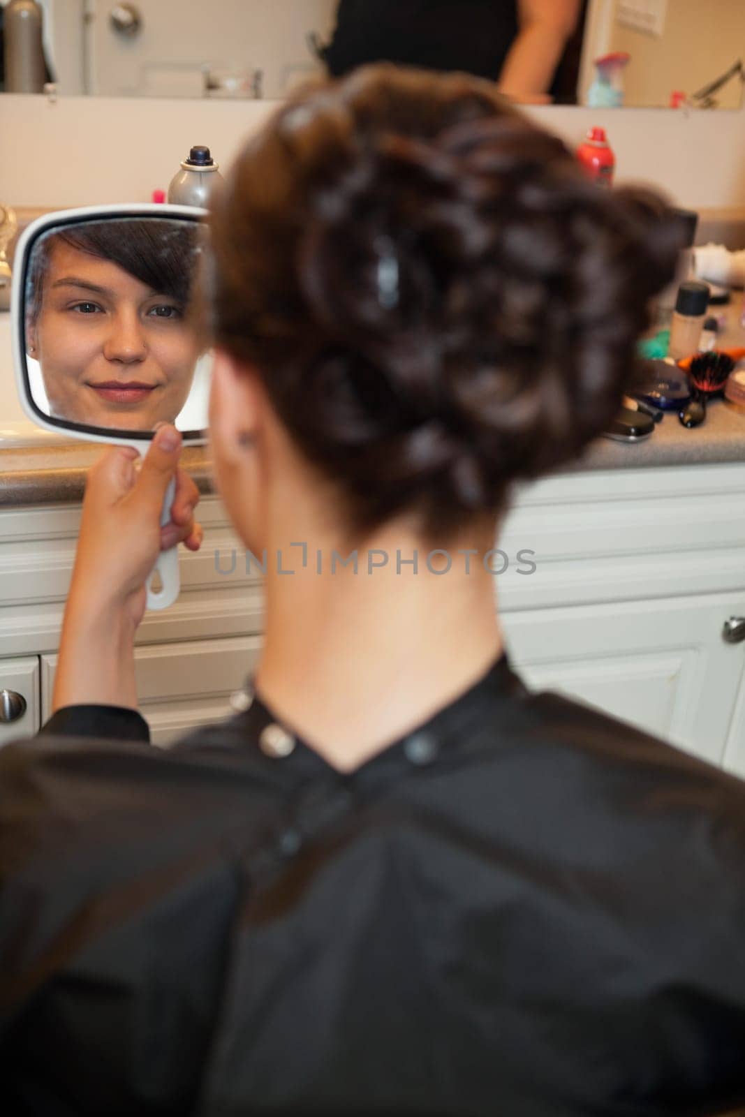 Bride looking in mirror at hair style before wedding