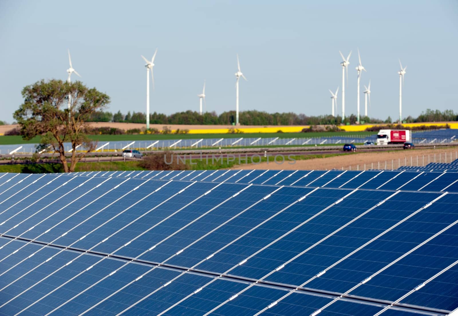 Wind turbines and solar panels in a rapeseed field