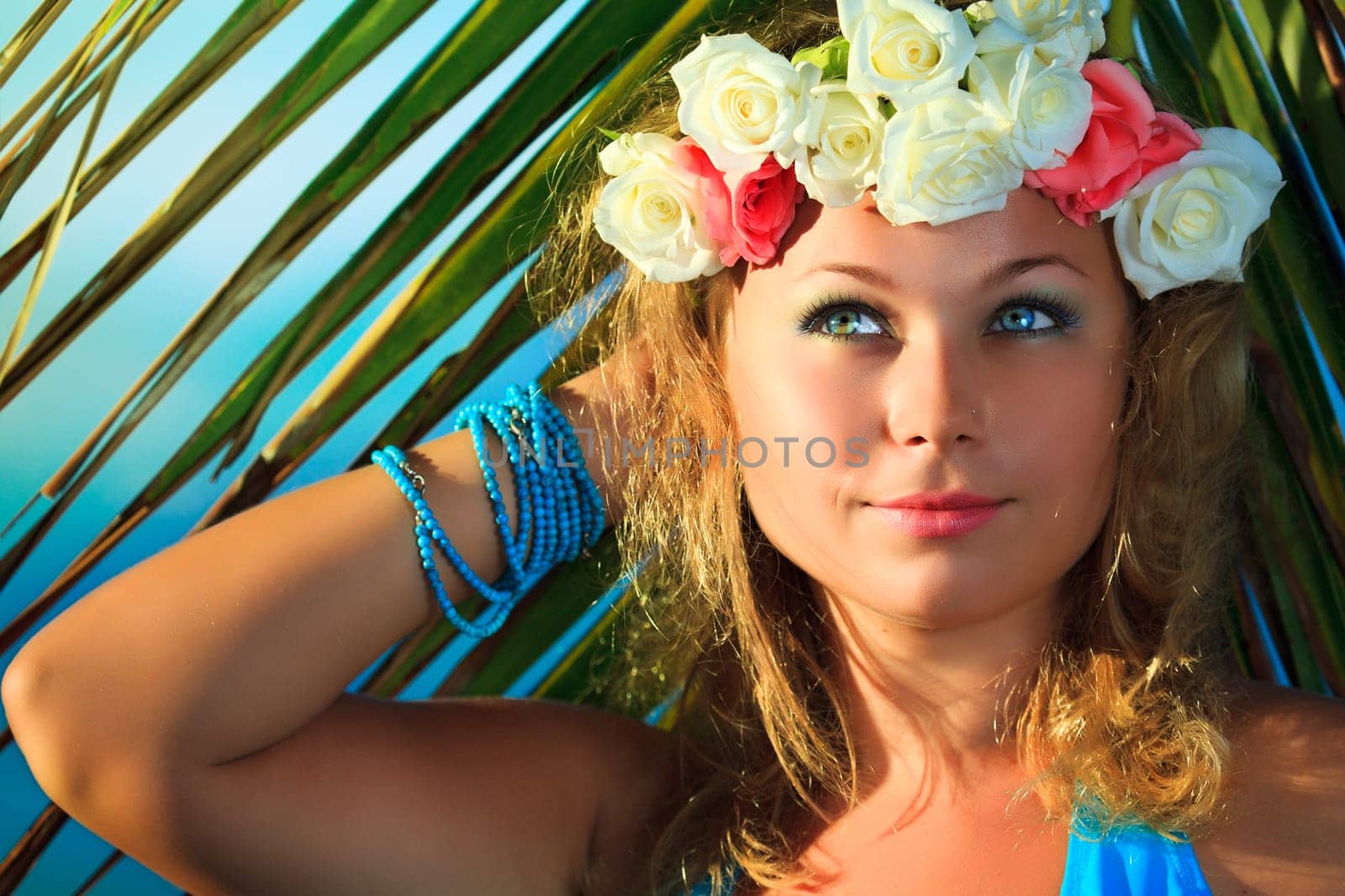 Woman in flower diadem on the beach
