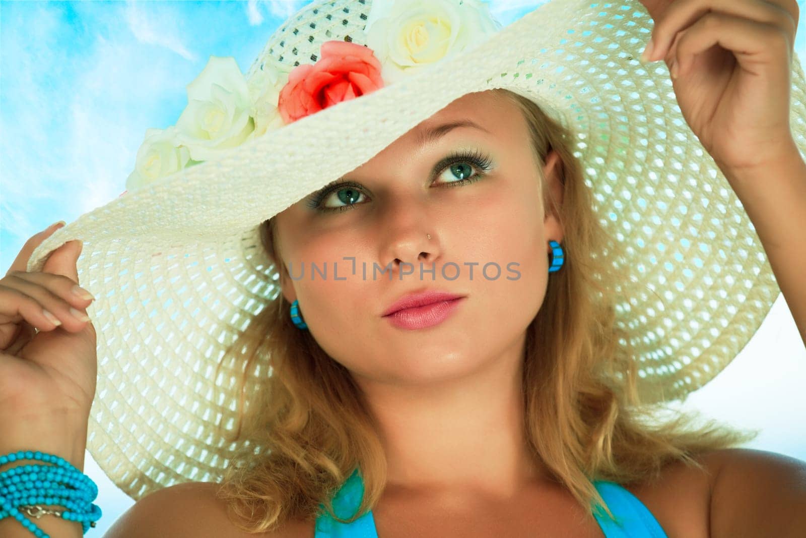 Young beautiful woman in hat with flowers