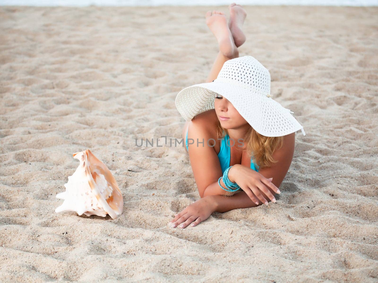 Young woman sunbathing on the tropical beach