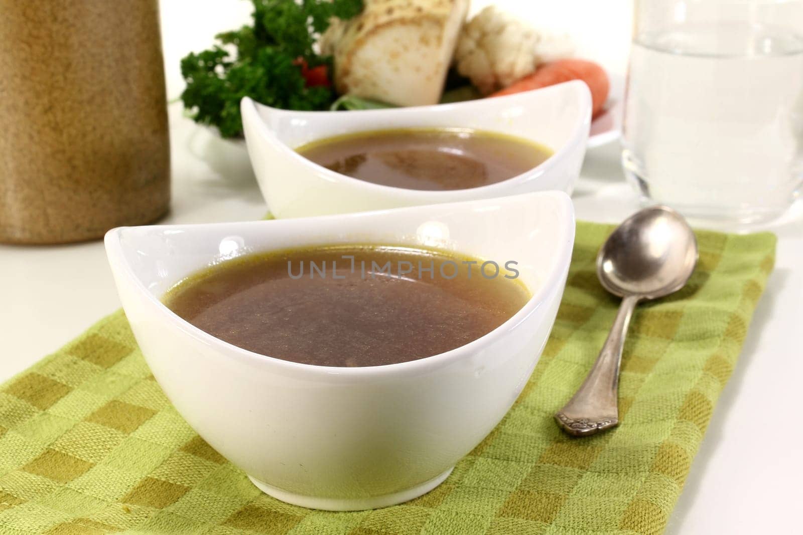two bowls of beef consommé on a napkin