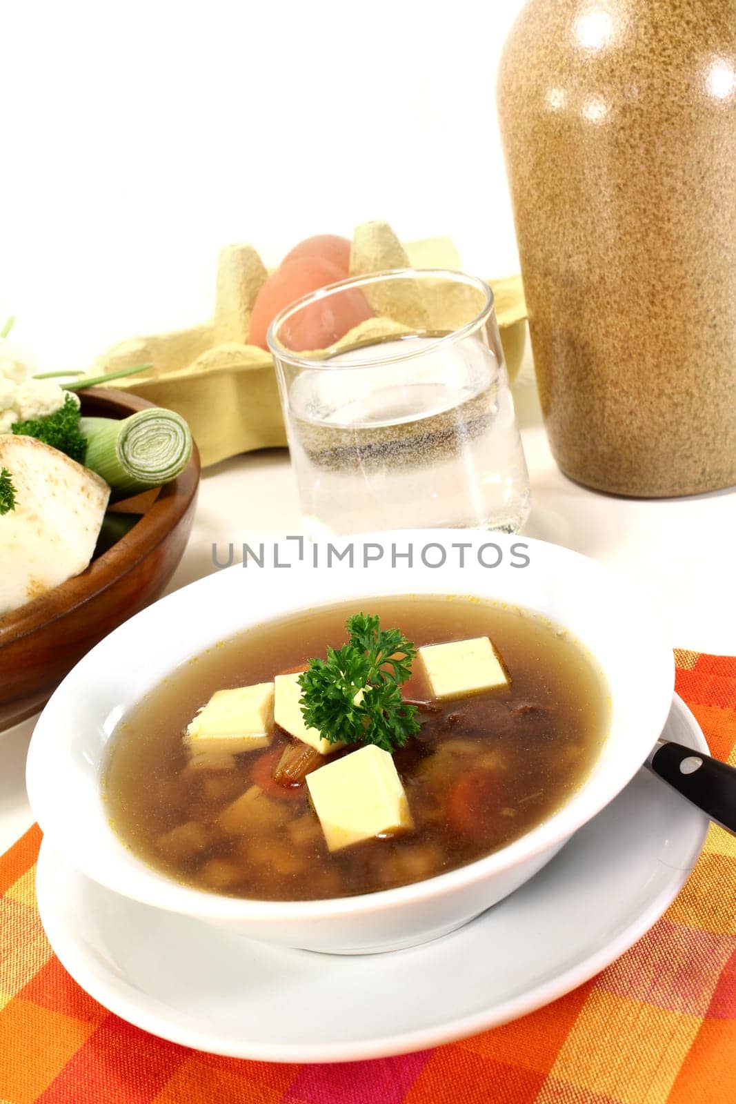 a bowl of beef consommé with egg custard and parsley