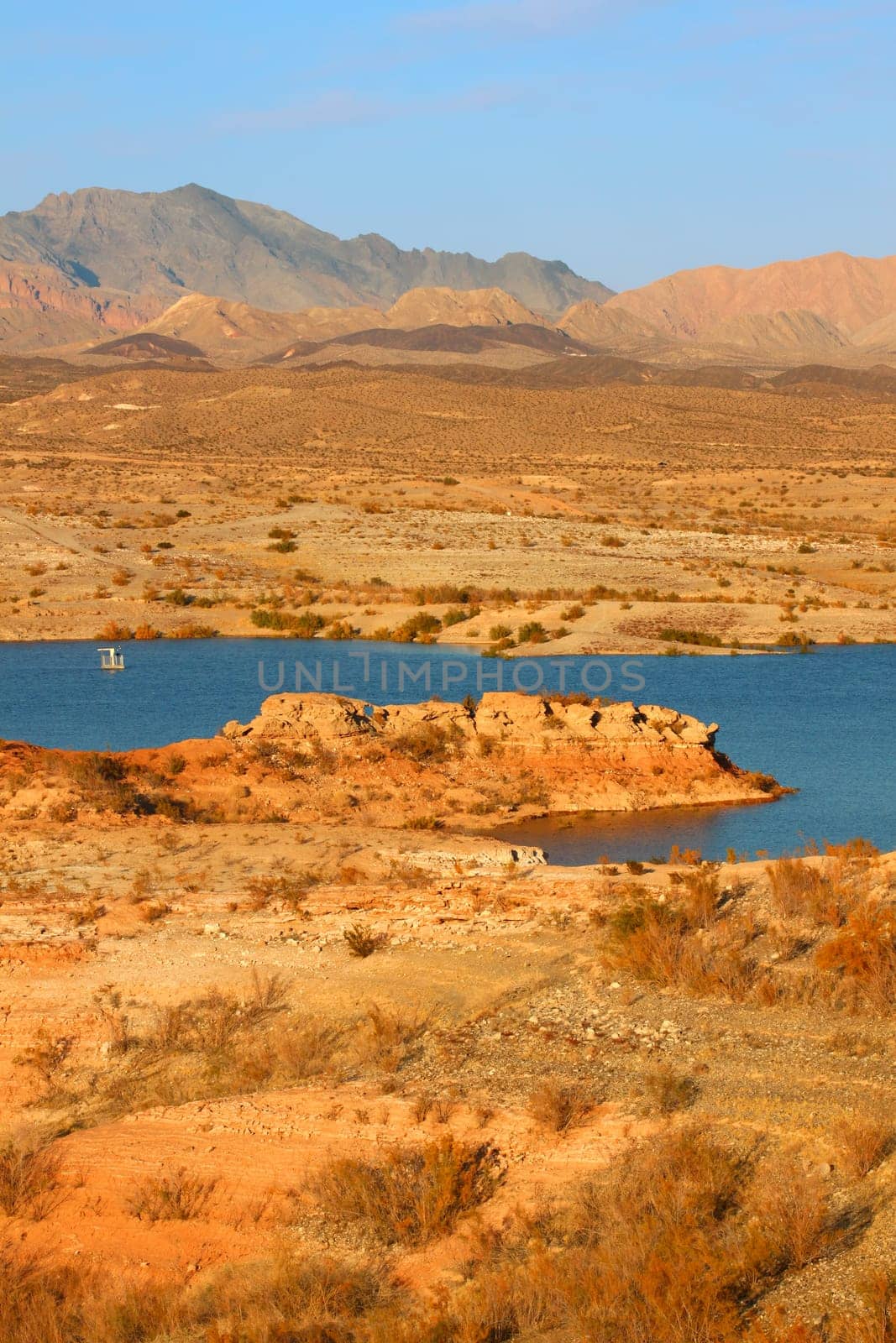 Evening sunlight creates striking colors on the rocky shoreline of Lake Mead in Nevada.