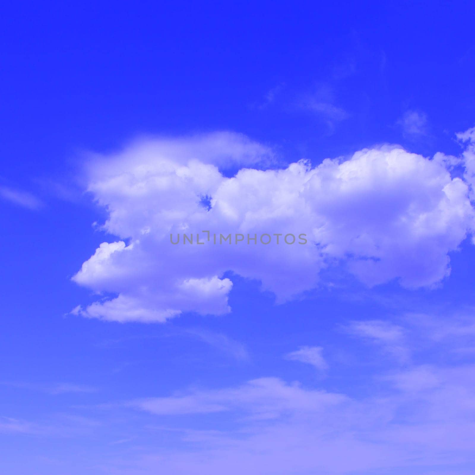 Puffy clouds set against a bright blue sky .