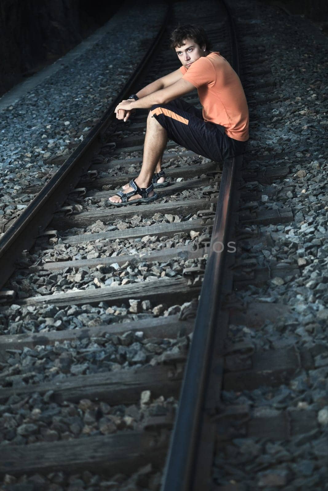 Young handsome men is sitting on train track
