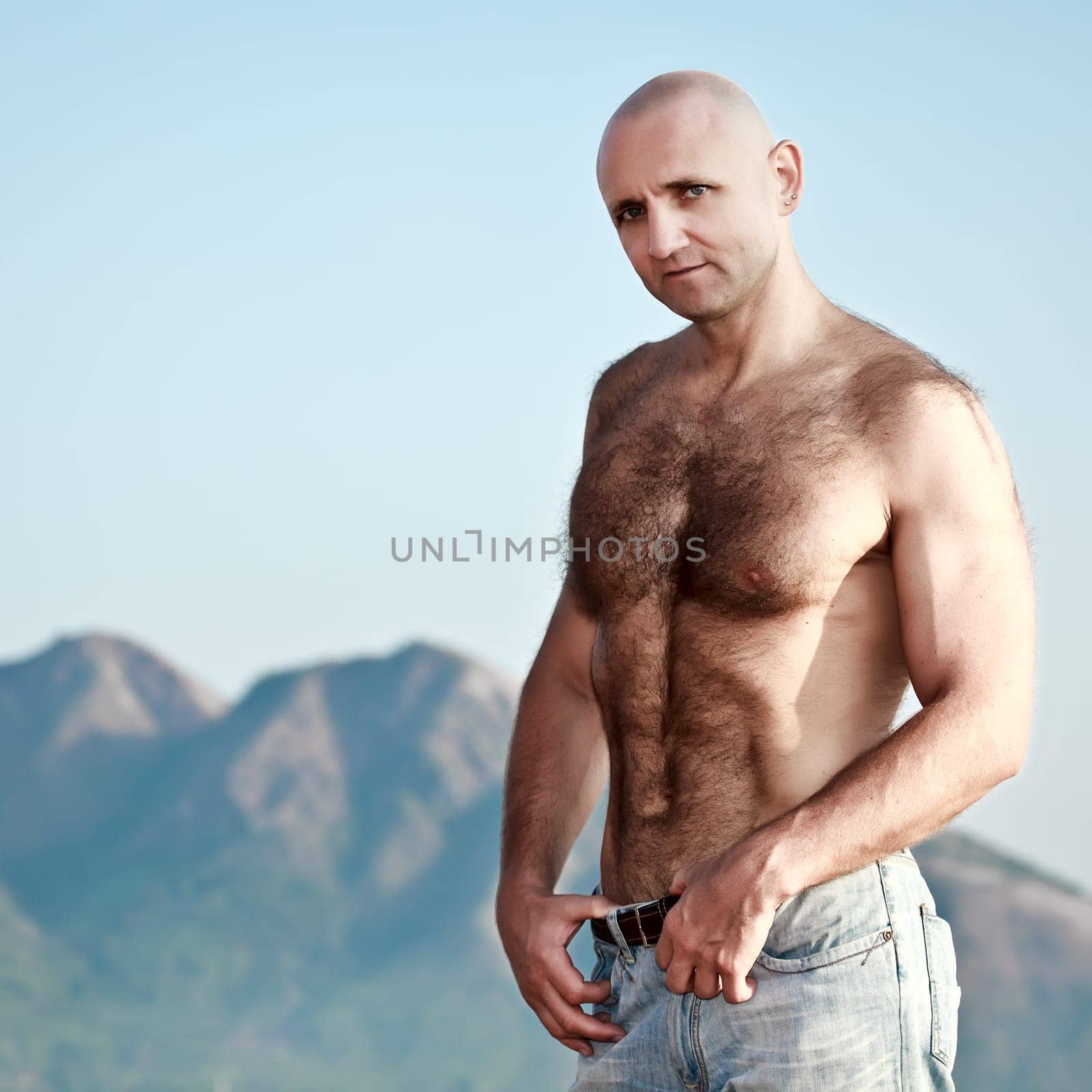 Muscular, handsome man in the background of  mountains