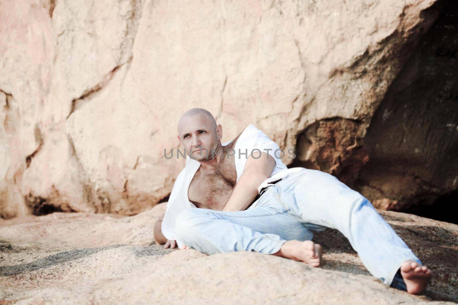 Handsome man lies on the rock outdoor