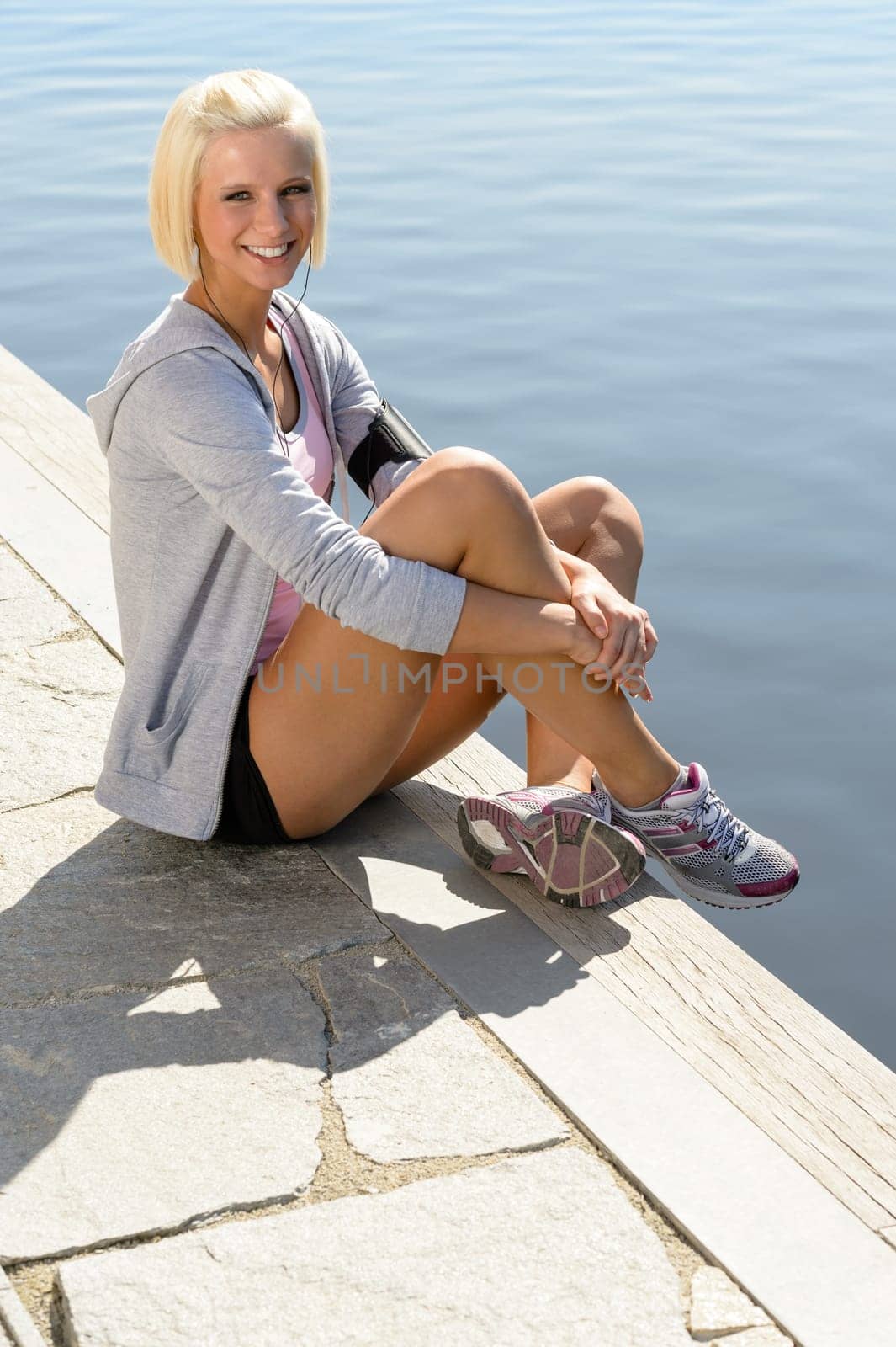Sport woman summer relax sitting by water pier