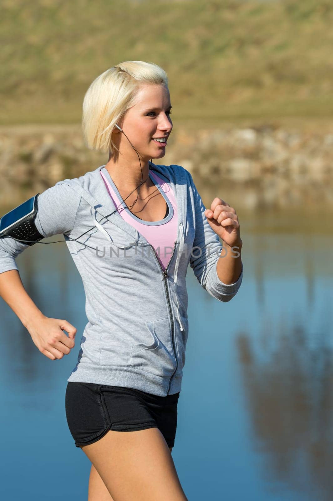 Young woman jogging recreational running by river sunny day
