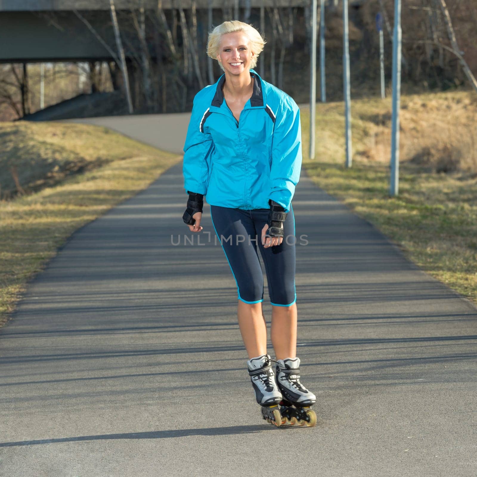 Happy woman roller skating sport smiling in park sunny day