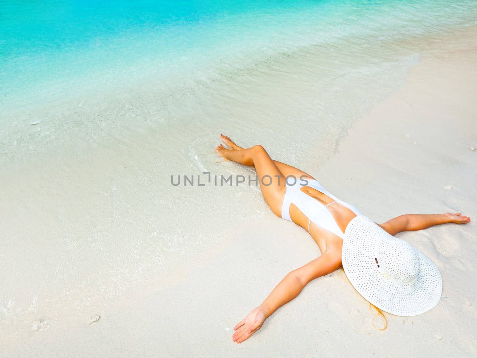 Beautiful woman sunbathing on the sandy beach.