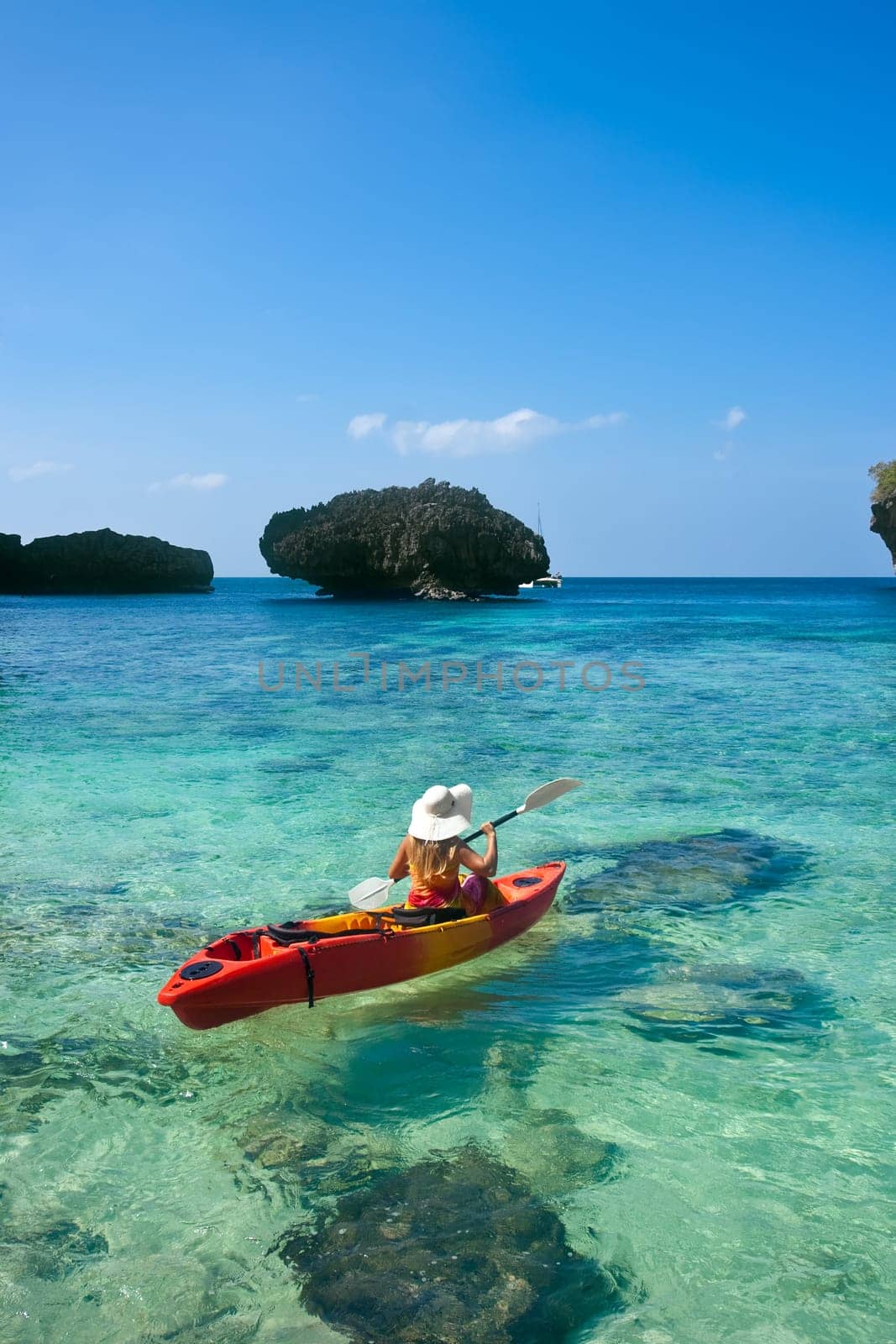 Young woman is kayaking in tropical lagoon