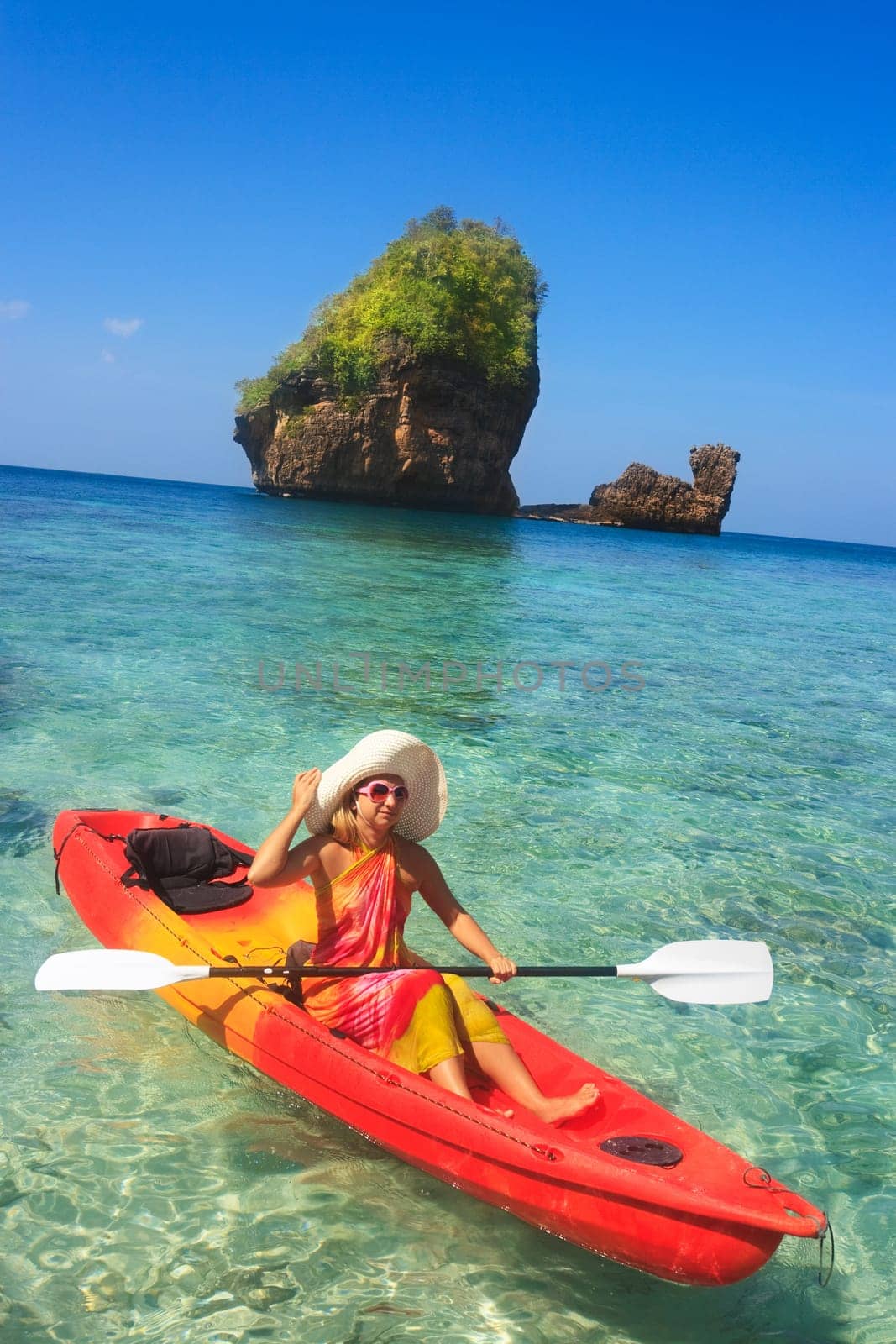 Young woman is kayaking in tropical lagoon
