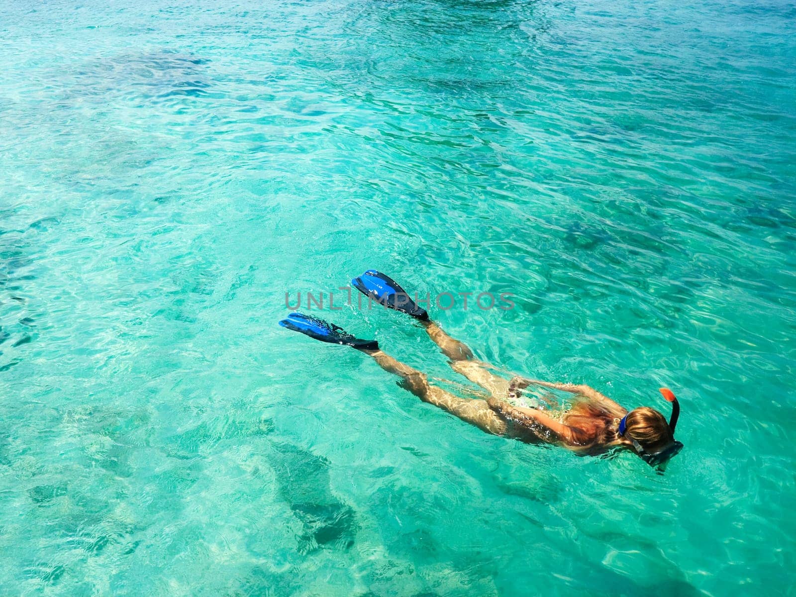 Young woman is snorkeling in tropical lagoon