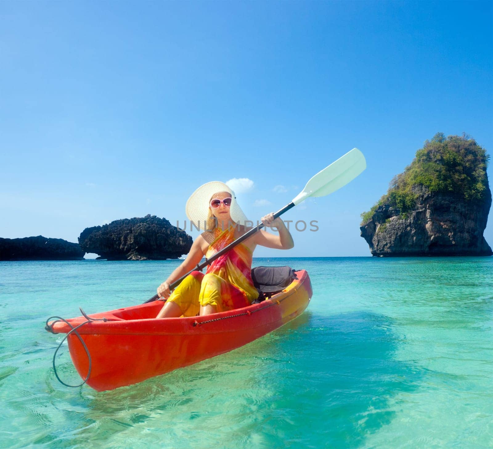 Young woman is Kayaking in tropical lagoon