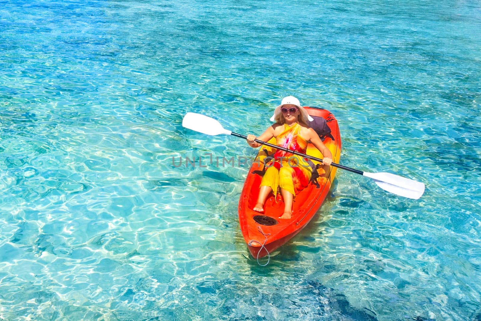 Young woman is Kayaking in tropical lagoon