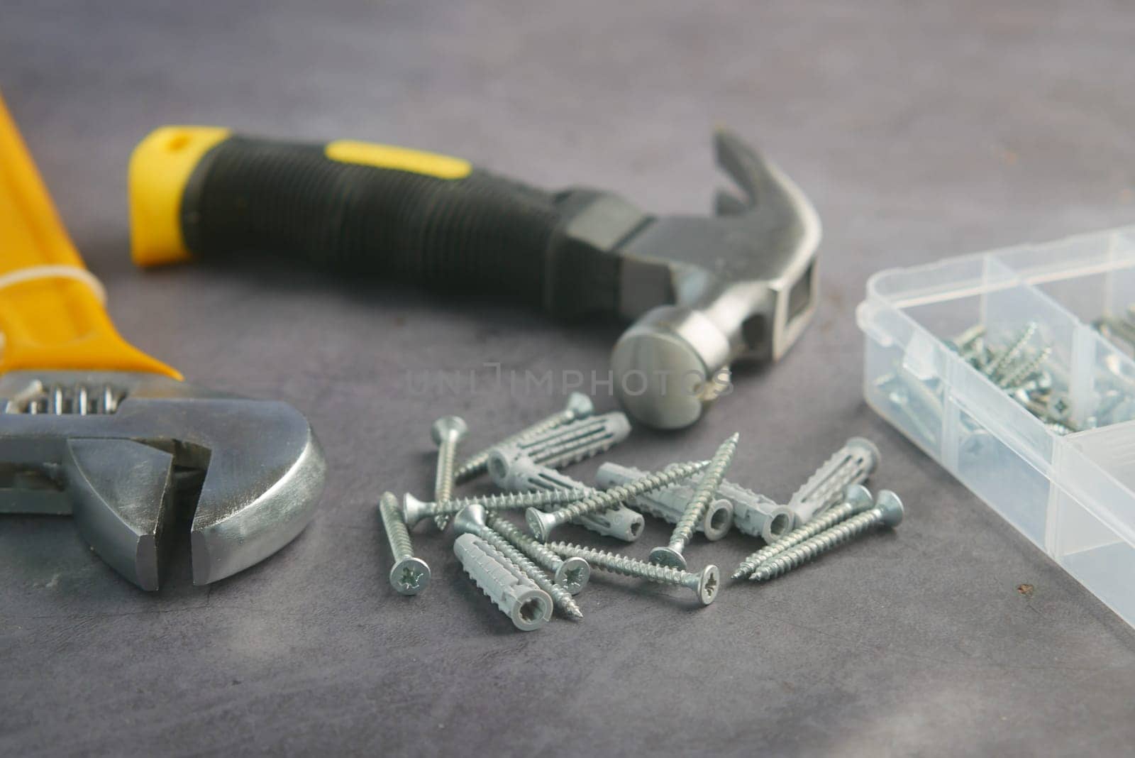 Various tools and screws are displayed on a work surface for repairs.