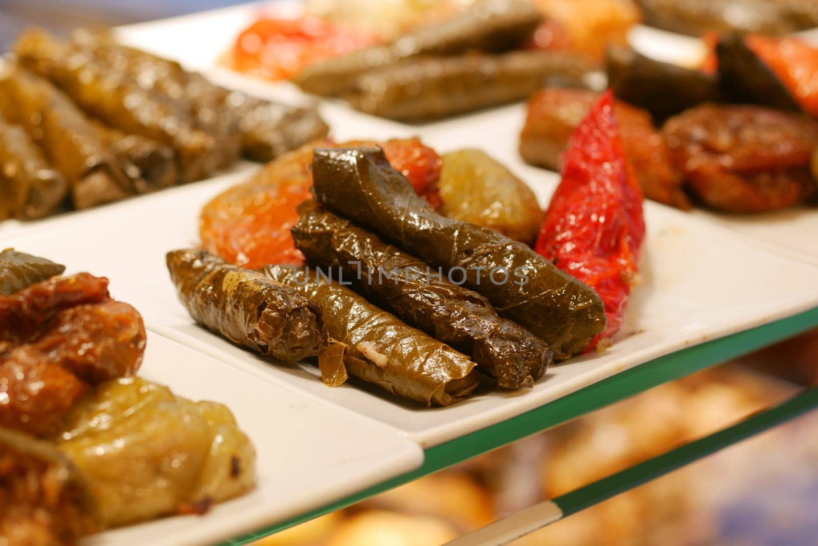 Colorful display of stuffed grape leaves and roasted vegetables served.
