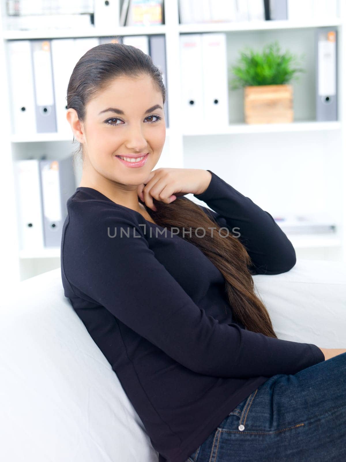 Young woman sitting on couch in her home