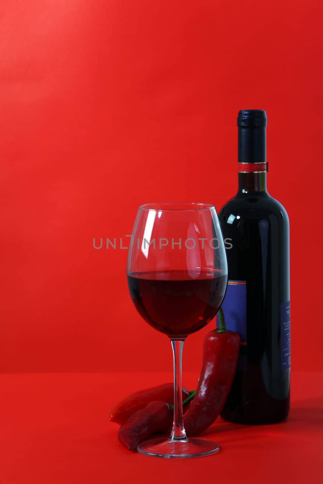 Red wine and glass with red background