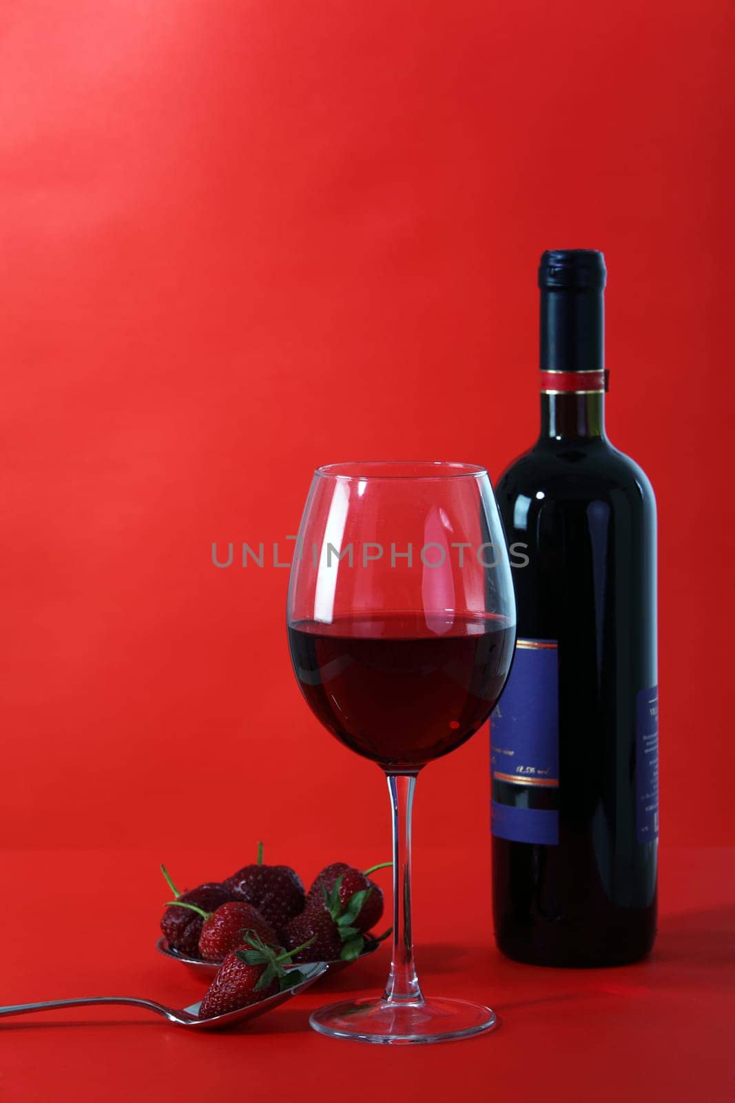 Red wine and glass with red background