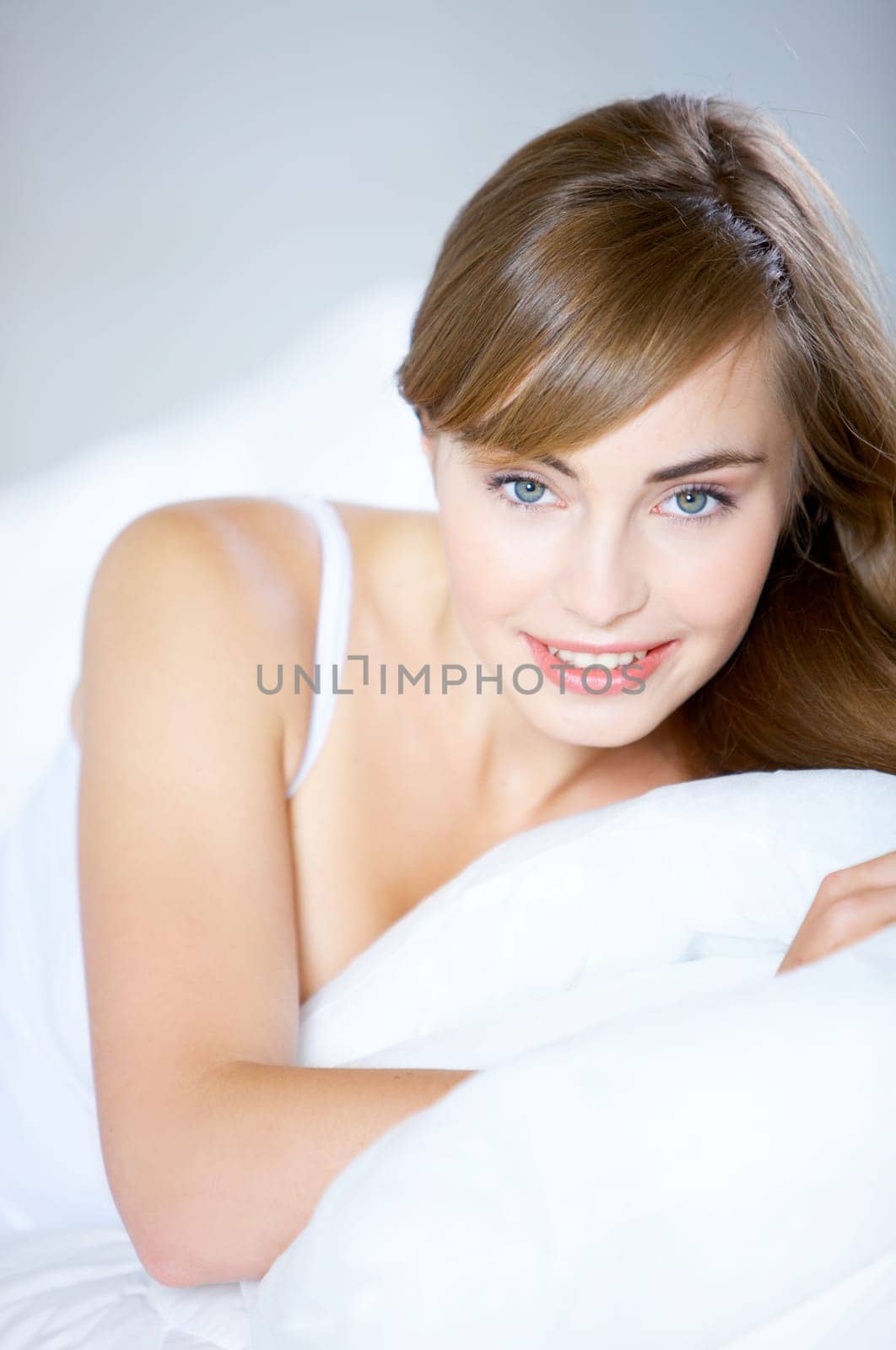 Beautiful teenager on white bed at her home