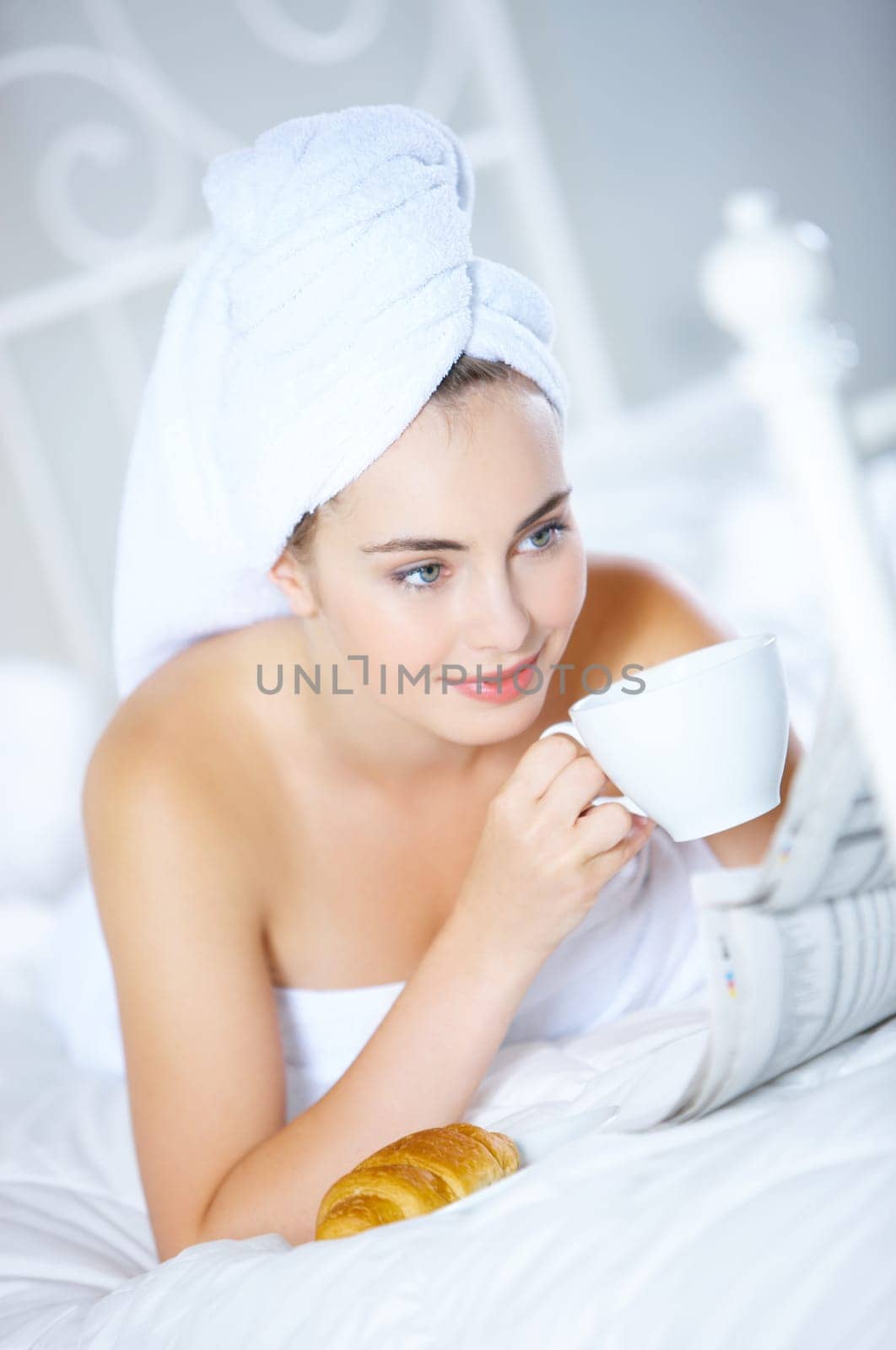 Portrait of cute teenage girl lying on white bed