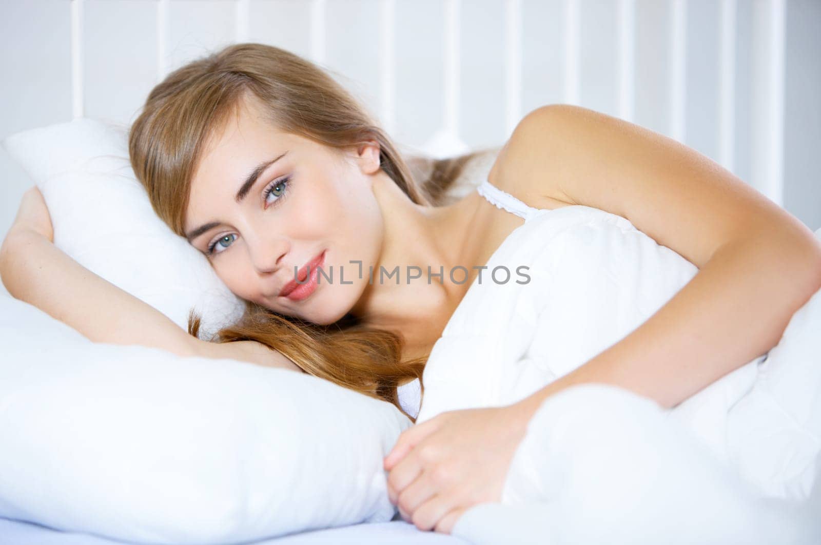 Beautiful teenager on white bed at her home