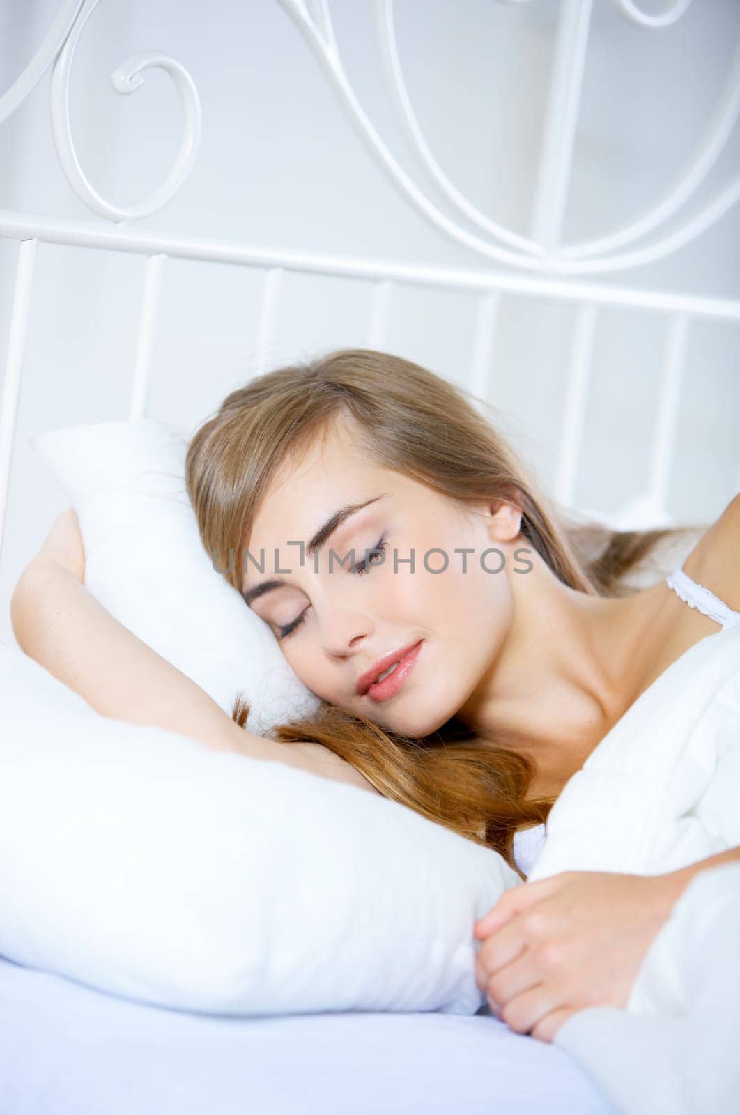 Beautiful teenager on white bed at her home