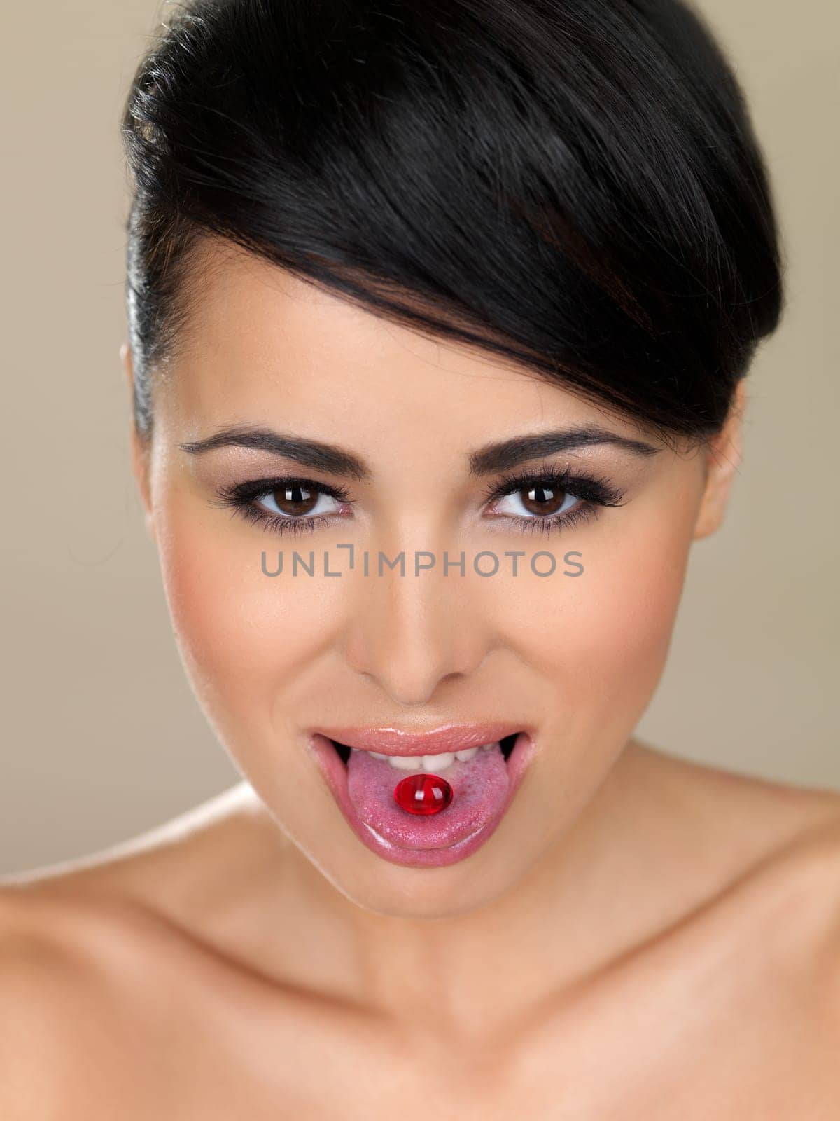 Portrait of beautiful woman, she has pill on her tongue