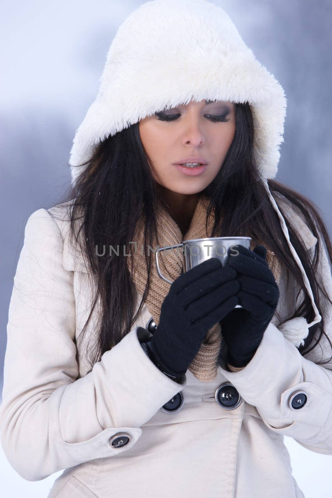 Beautiful holding mug in snowy winter outdoors