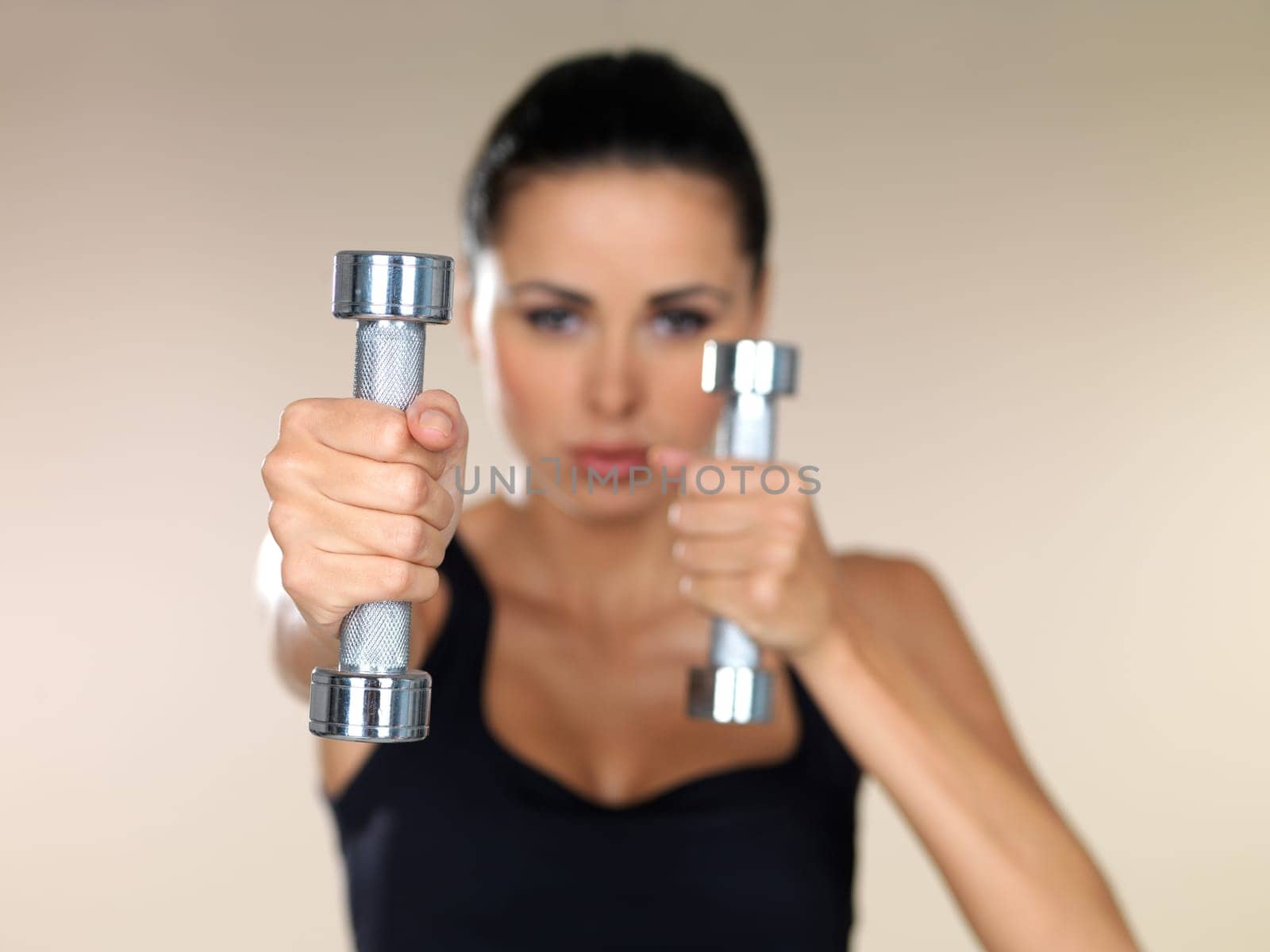Young beautiful woman during fitness time with dumbbells