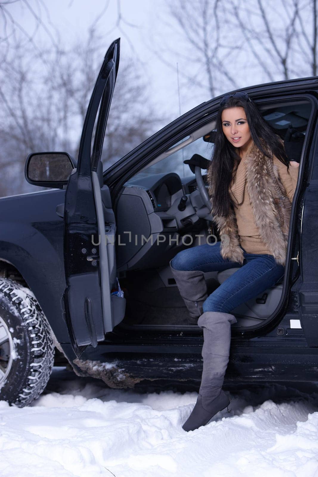 Beautiful woman in car in snowy winter outdoors