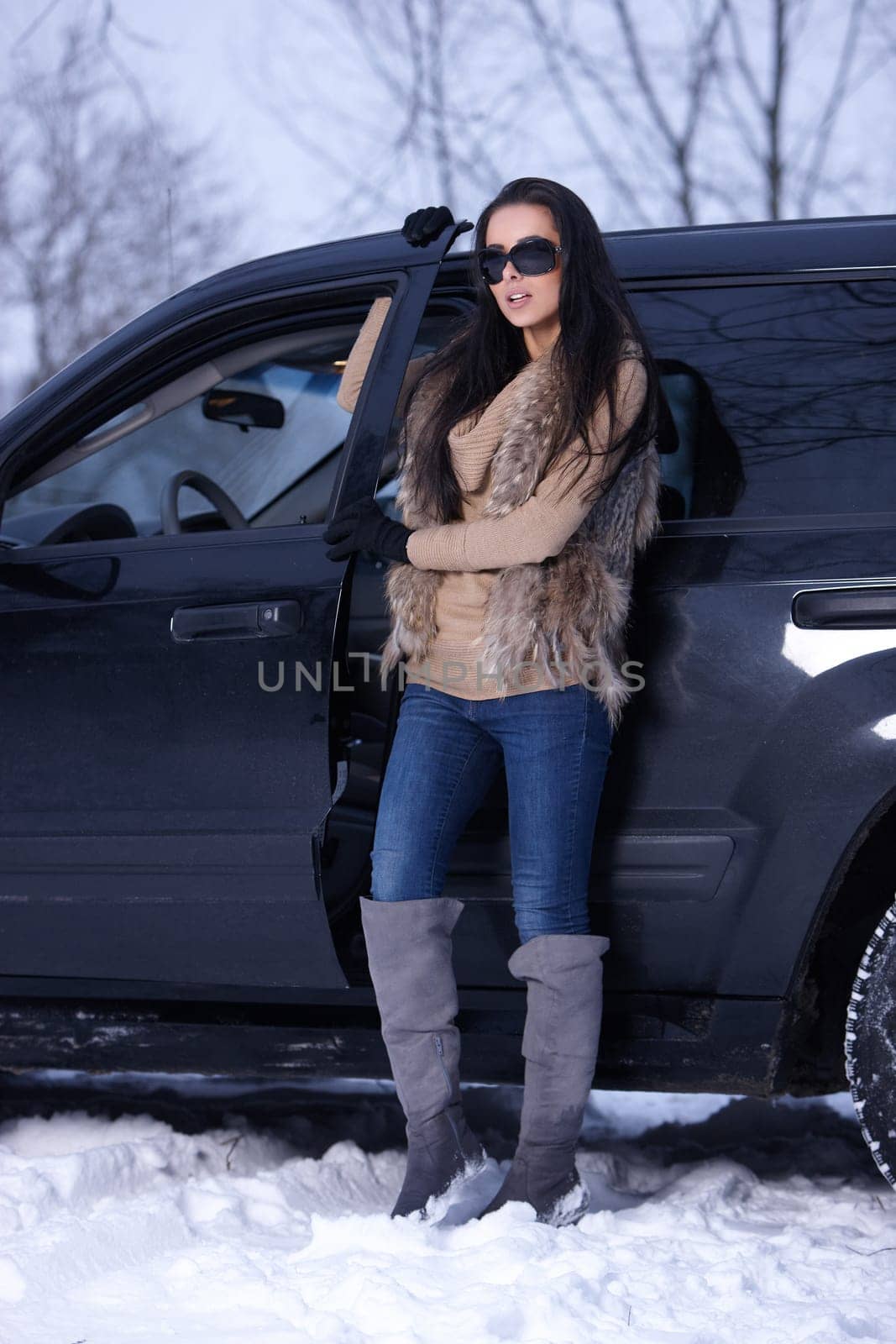 Beautiful woman in car in snowy winter outdoors