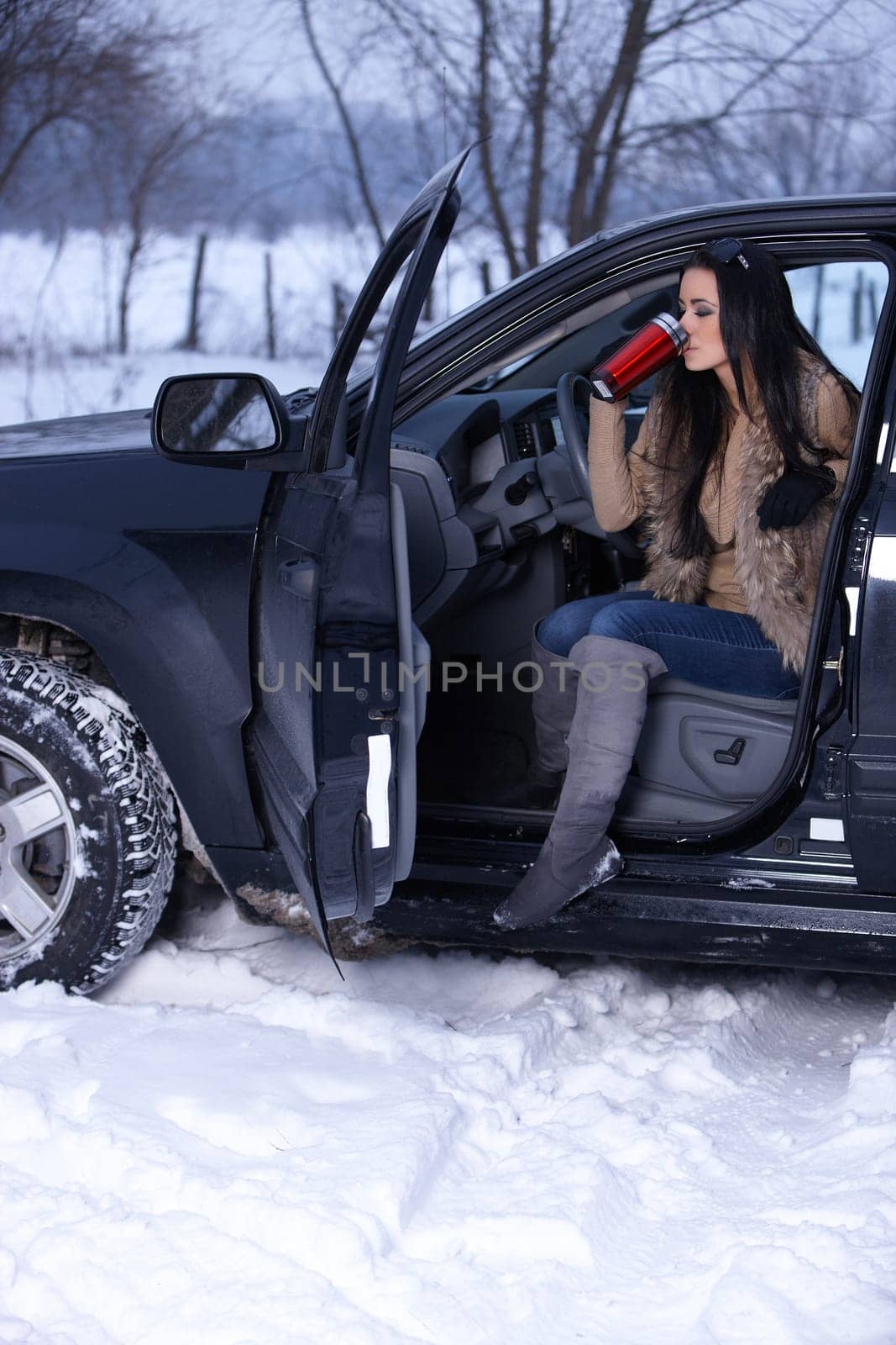 Beautiful woman in car in snowy winter outdoors