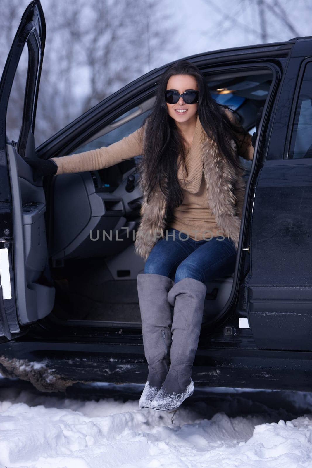 Beautiful woman in car in snowy winter outdoors