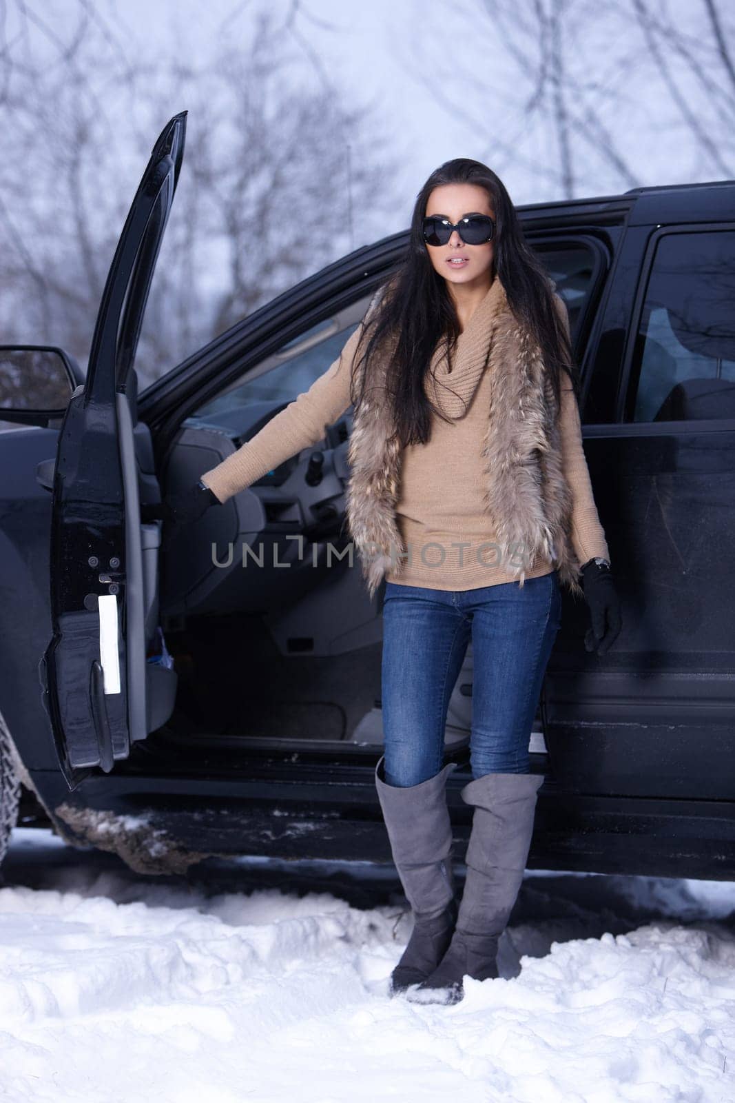 Beautiful woman in car in snowy winter outdoors