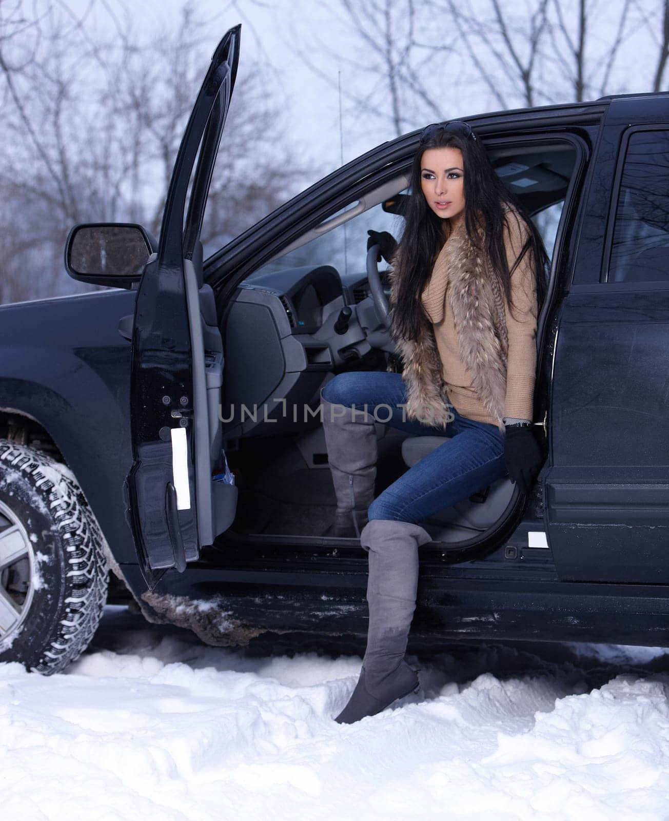 Beautiful woman in car in snowy winter outdoors