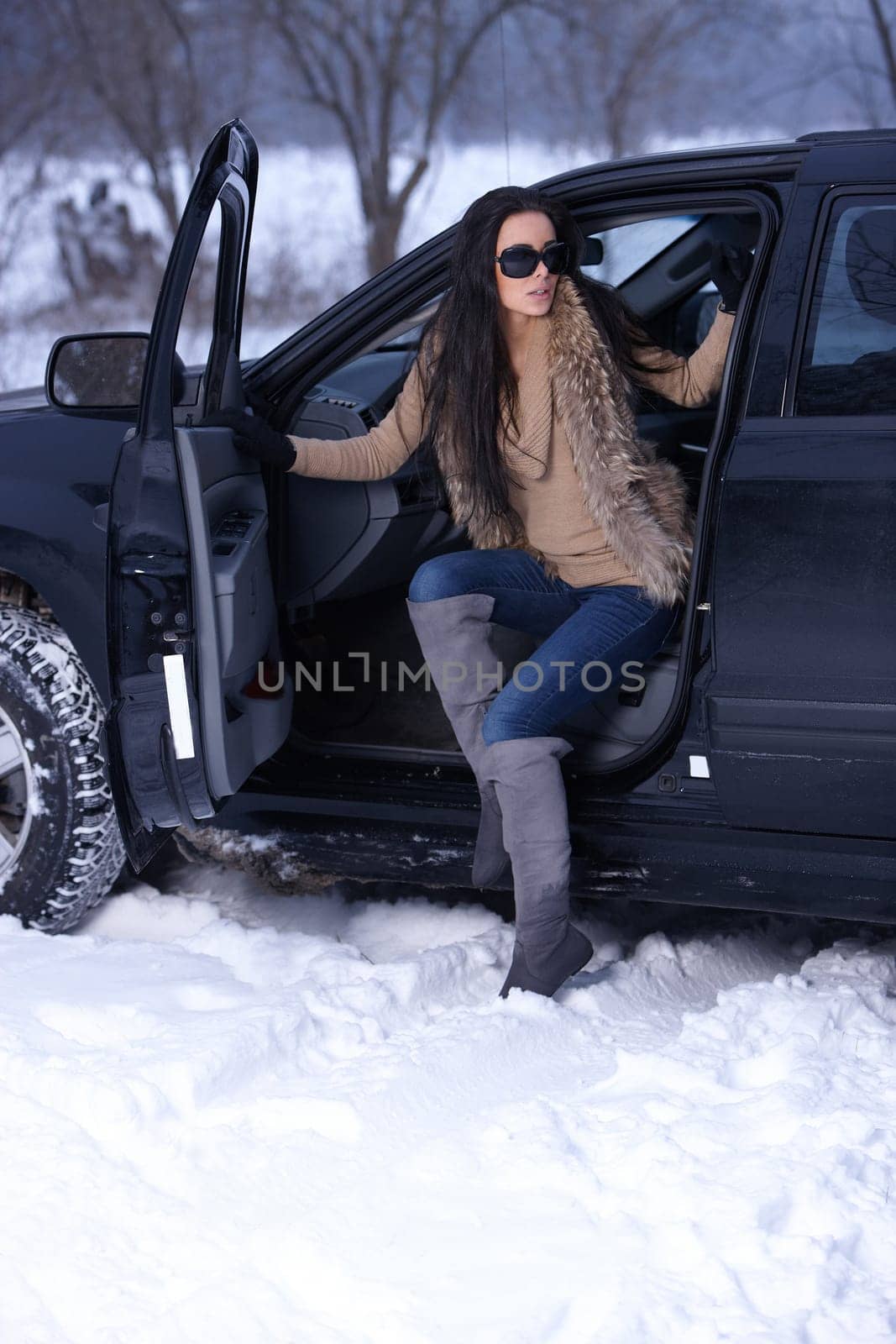 Beautiful woman in car in snowy winter outdoors