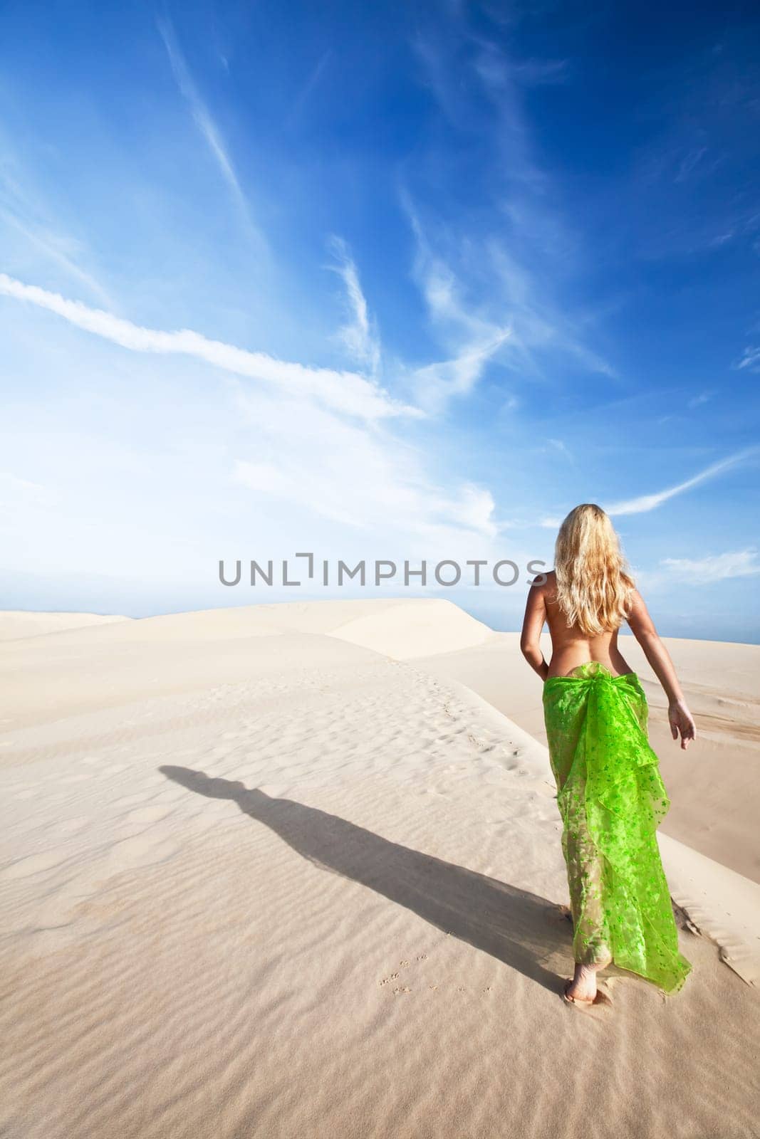 Woman walking in the middle of desert