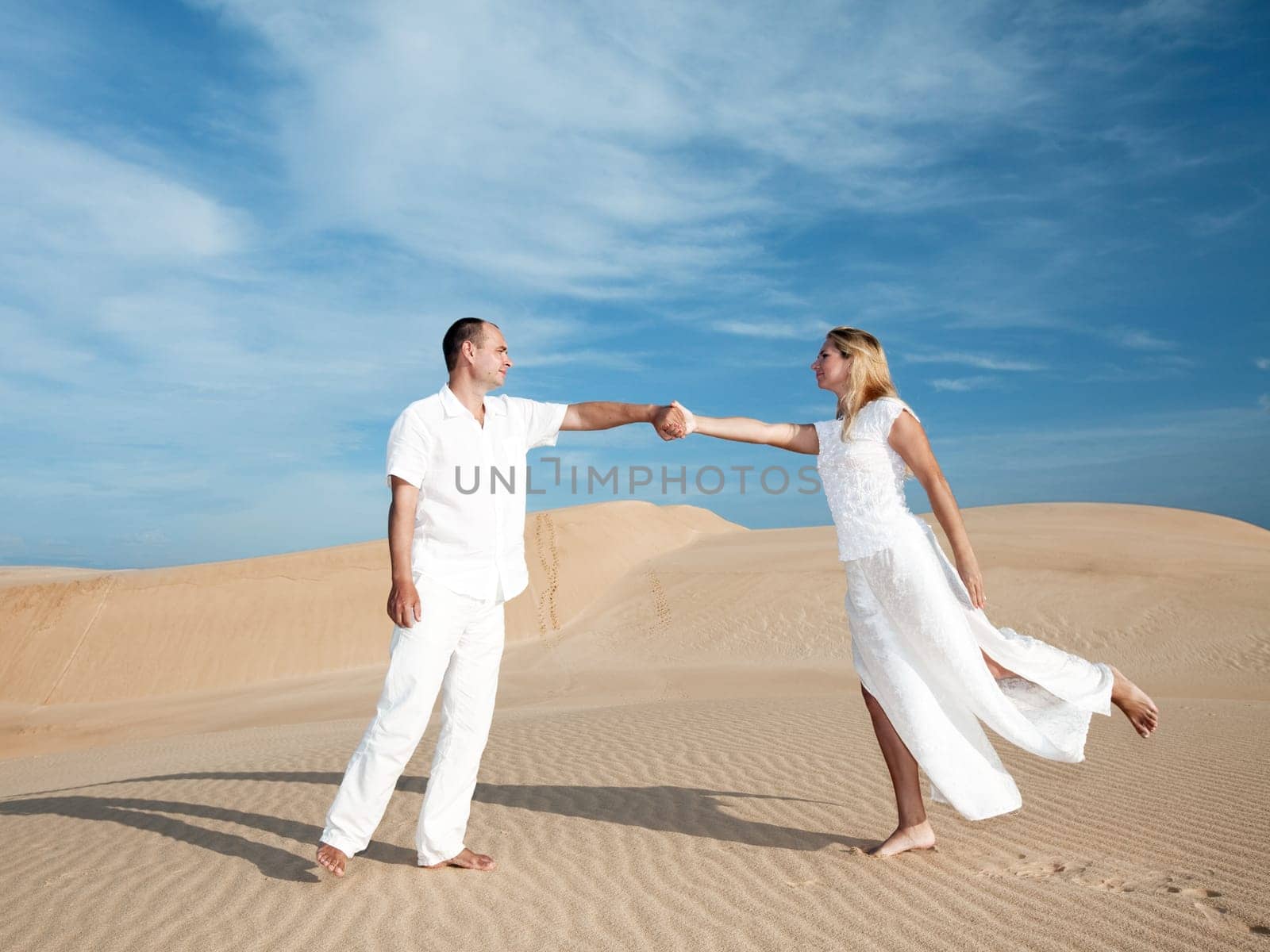 Meeting of men and woman at desert dunes
