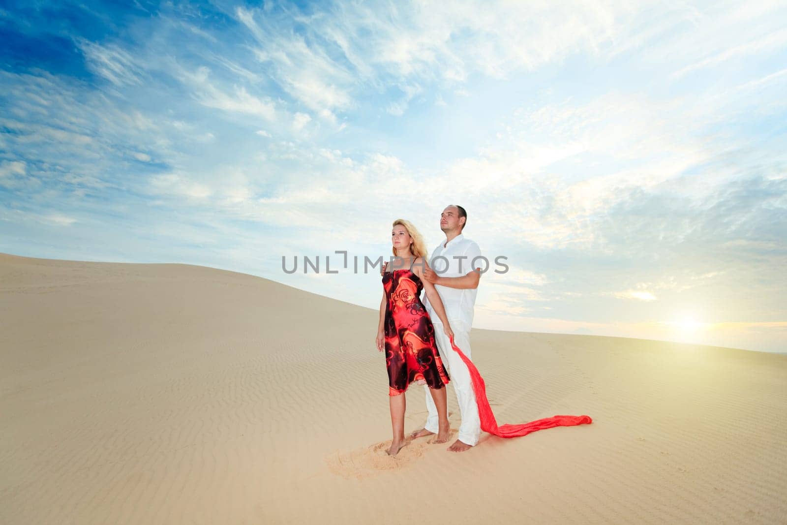 Young beautiful couple in desert at sunrise time