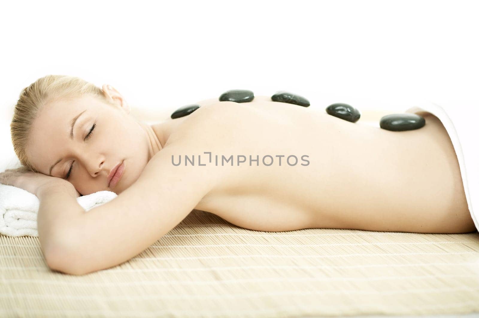 Young blond woman getting lastone treatment at spa