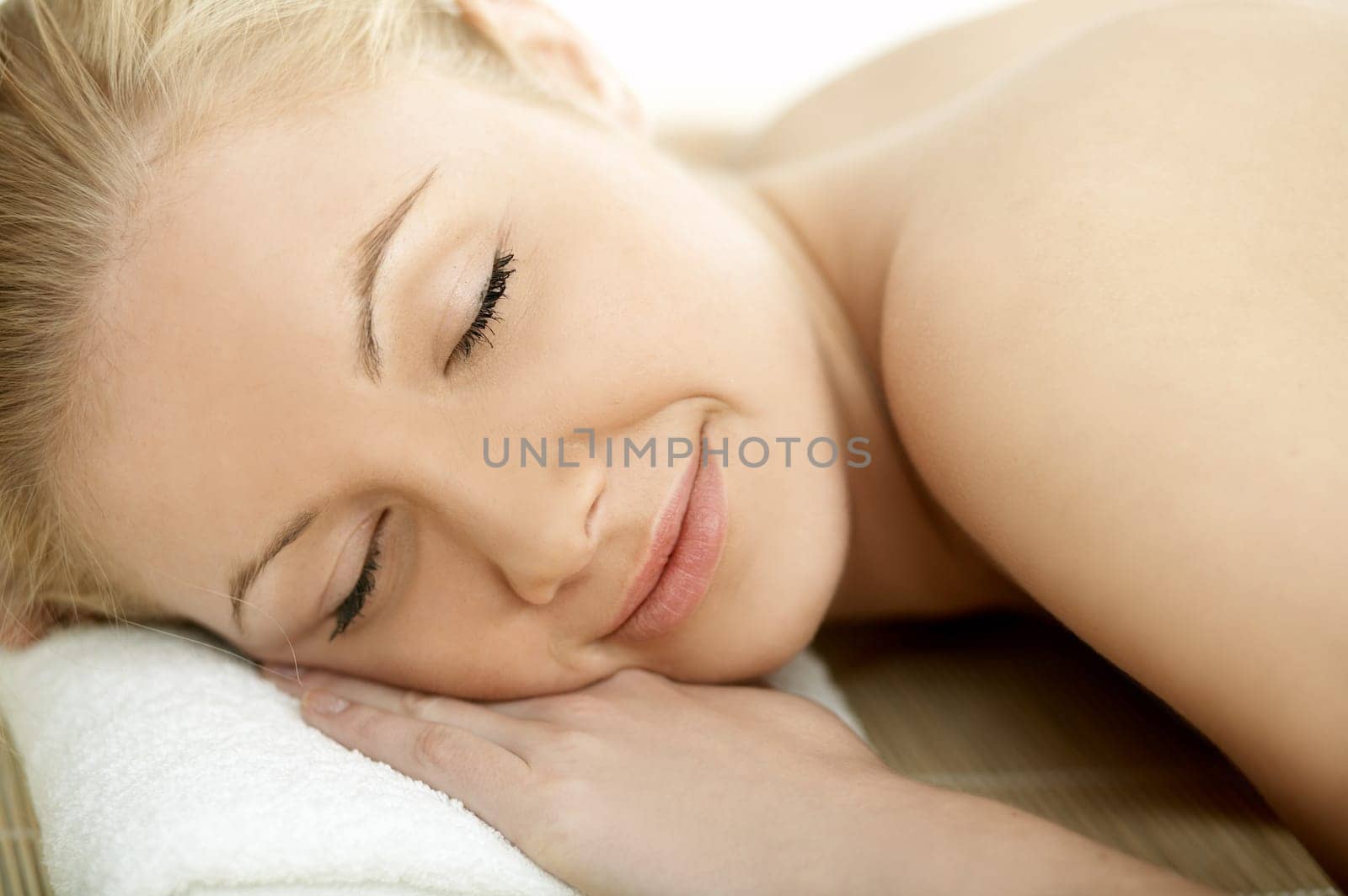Portrait of Fresh and Beautiful blond woman laying on bamboo mat
