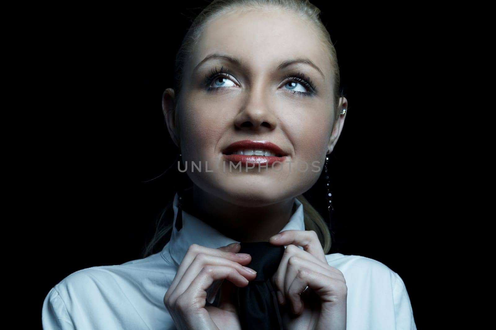 Beautiful business woman wearing black tie and white shirt isolated on black background