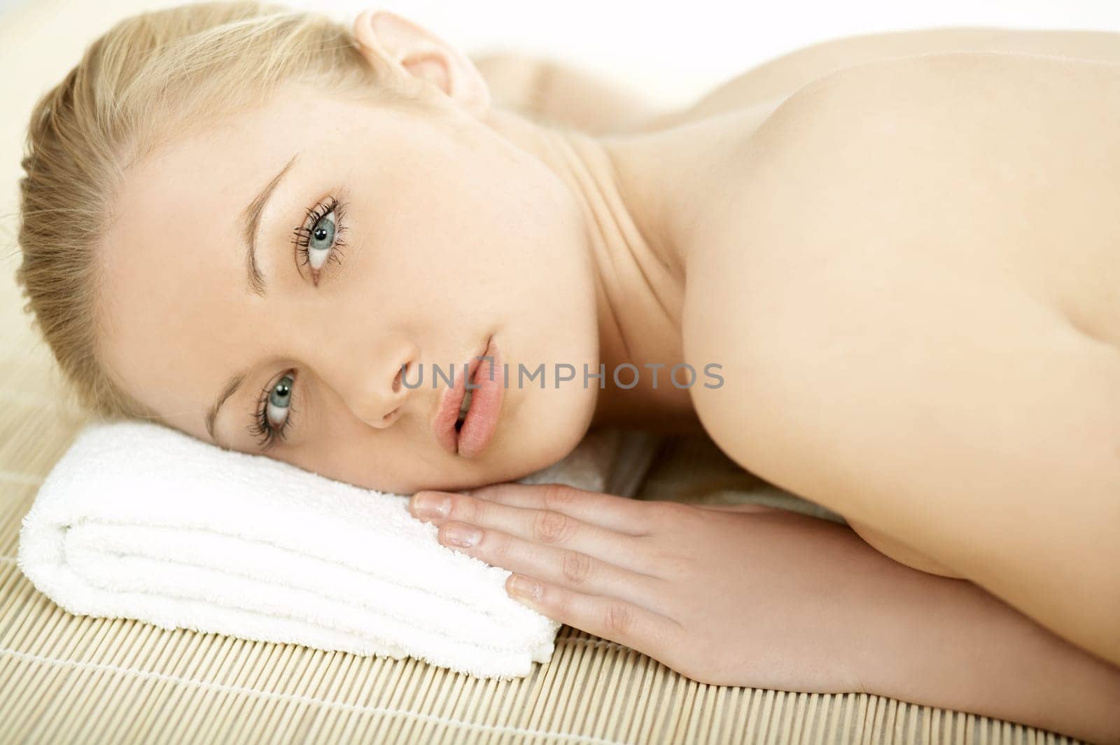 Portrait of Fresh and Beautiful blond woman laying on bamboo mat