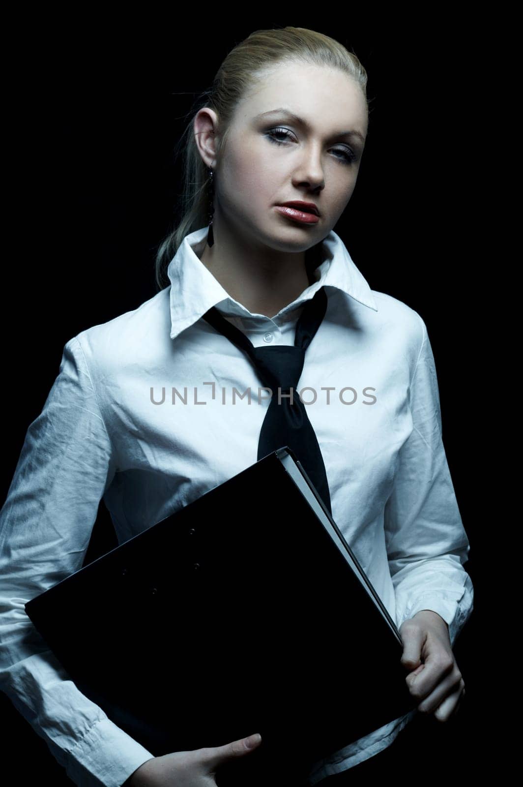 Beautiful business woman wearing black tie and white shirt holding folder isolated on black background