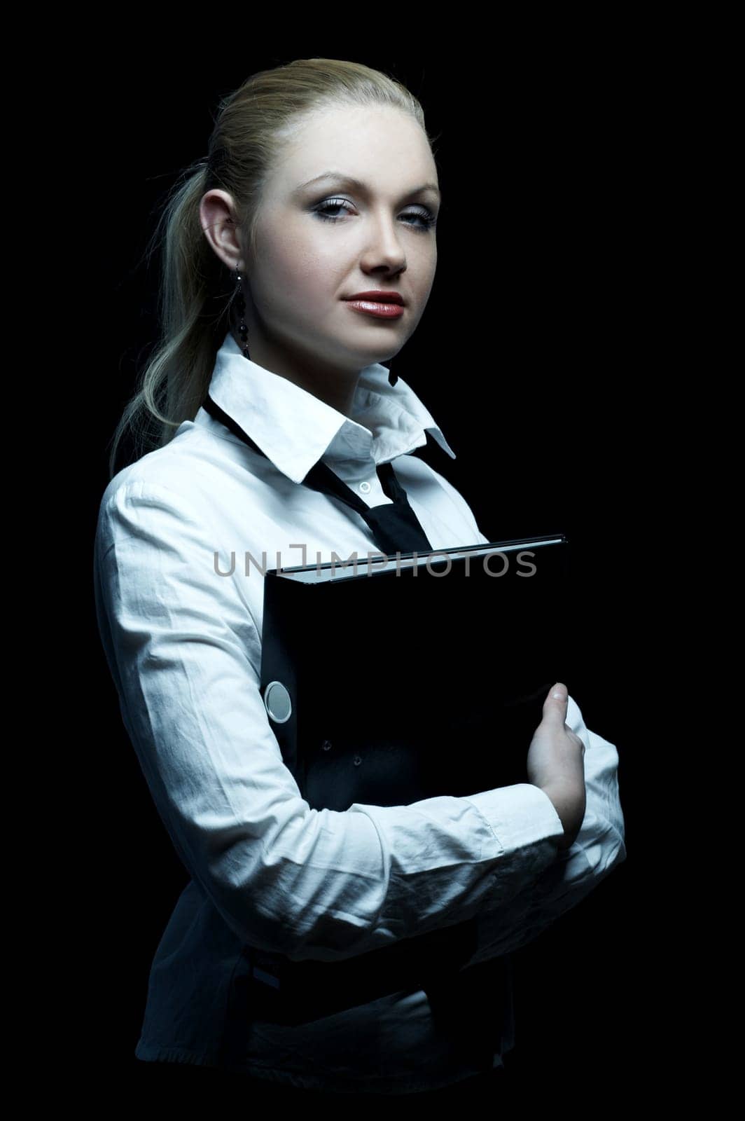 Beautiful business woman wearing black tie and white shirt holding folder isolated on black background