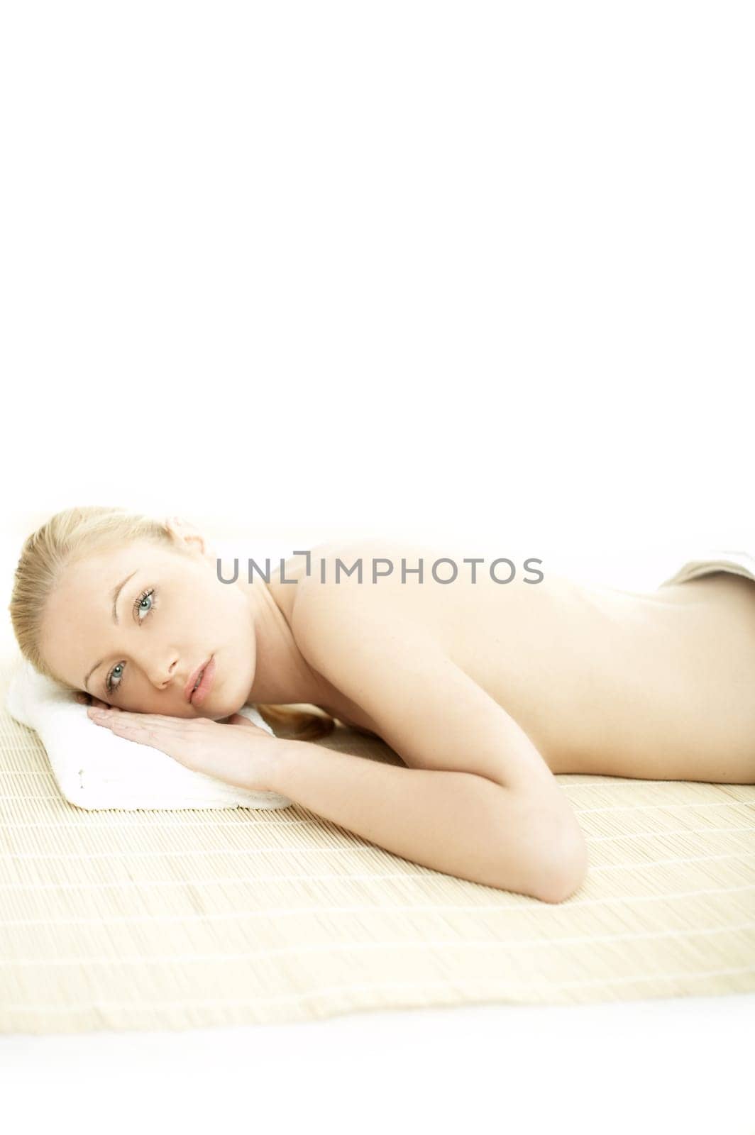 Portrait of Fresh and Beautiful blond woman laying on bamboo mat